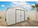 Durable, light-colored storage shed with double door in backyard, offering ample storage at 430 Nancy Dr, Henderson, NV 89015