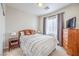 Well-lit bedroom with large window, dresser, and decorative pillows at 4630 Basilicata Ln # 203, North Las Vegas, NV 89084