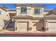 Inviting condo building featuring tan siding, multi-car garages, and stairs to upper units at 4630 Basilicata Ln # 203, North Las Vegas, NV 89084