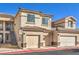 Inviting condo building featuring tan siding, multi-car garages, and stairs to upper units at 4630 Basilicata Ln # 203, North Las Vegas, NV 89084