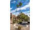 Well-maintained community features desert landscaping, mature palm trees, and a decorative stone water feature with concrete curbing at 4941 River Glen Dr # 4, Las Vegas, NV 89103