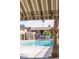 Community swimming pool with striped awning and palm trees at 4941 River Glen Dr # 4, Las Vegas, NV 89103