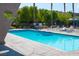 Beautiful blue swimming pool with lounge chairs, palm trees, and lovely landscaping at 4941 River Glen Dr # 4, Las Vegas, NV 89103