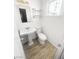 Cozy bathroom featuring white fixtures, a pedestal sink, updated floors and a large mirror at 5305 Alta Dr, Las Vegas, NV 89107