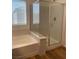 Modern bathroom featuring tub, shower, wood-look floors and blinds for privacy and natural light at 5773 Fresh Fields Ct, Las Vegas, NV 89118