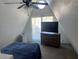 Bright bedroom with a ceiling fan, a TV on a dresser, and a door to the exterior at 6171 Whispering Sands Dr, Las Vegas, NV 89131