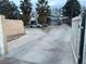 Charming front exterior with a long driveway, mature palm trees, and a gated entrance at 6171 Whispering Sands Dr, Las Vegas, NV 89131