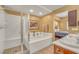 Bright primary bathroom with a jacuzzi tub, walk in shower and dual sinks next to primary bedroom at 64 Strada Principale # 307, Henderson, NV 89011
