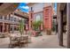 Charming courtyard features stylish outdoor seating, decorative umbrellas, and lush landscaping at 64 Strada Principale # 307, Henderson, NV 89011