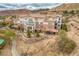 Stunning aerial view of a multi-story condo complex with a red tile roof, surrounded by lush landscaping at 64 Strada Principale # 307, Henderson, NV 89011