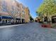 Inviting street view lined with cafes and shops, featuring outdoor seating and lush green trees at 64 Strada Principale # 307, Henderson, NV 89011