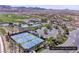 Aerial view of tennis courts, pool and clubhouse with desert landscape and mountain views in the Lake Las Vegas community at 64 Strada Principale # 307, Henderson, NV 89011