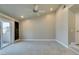 Spacious bedroom with neutral walls, carpet flooring, ceiling fan and doors to the exterior at 7131 Mission Hills Dr, Las Vegas, NV 89113