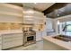 Modern kitchen boasts stainless steel stove, unique backsplash, and sleek white cabinetry with open shelving at 7131 Mission Hills Dr, Las Vegas, NV 89113
