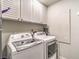 Bright laundry room showcasing a modern washer and dryer, with ample storage cabinets above at 7131 Mission Hills Dr, Las Vegas, NV 89113