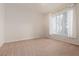 Empty carpeted room with window and curtains ready for staging or decorating at 7163 S Durango Dr # 108, Las Vegas, NV 89113