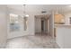 Sunlit dining area with stylish chandelier and tiled floors adjacent to kitchen at 7163 S Durango Dr # 108, Las Vegas, NV 89113
