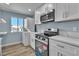 Well-lit kitchen with white cabinetry, stainless steel appliances, and a stacked washer and dryer at 725 N Royal Crest Cir # 237, Las Vegas, NV 89169