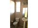 Cozy powder room with a pedestal sink, toilet, and decorative lighting fixture at 8348 Mokena Ave, Las Vegas, NV 89178