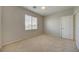 A cozy bedroom with neutral carpet and walls, a window, and a white door to the right at 8348 Mokena Ave, Las Vegas, NV 89178