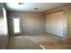 A well-lit living room featuring neutral carpet, walls and an exit door at 8348 Mokena Ave, Las Vegas, NV 89178