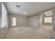 Bright living room featuring large windows and neutral carpet and paint, creating a welcoming atmosphere at 8348 Mokena Ave, Las Vegas, NV 89178