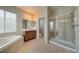 Spacious main bathroom featuring a soaking tub, a glass-enclosed shower, and vanity, promoting a relaxing retreat at 8348 Mokena Ave, Las Vegas, NV 89178
