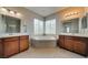 Luxurious main bathroom boasting dual vanities, a soaking tub, and abundant natural light from surrounding windows at 8348 Mokena Ave, Las Vegas, NV 89178