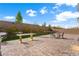 Beautiful backyard with a large paved patio, desert landscaping, and BBQ at 8415 Iron Heart Ln, Las Vegas, NV 89113