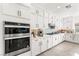 Clean kitchen featuring white cabinets, stainless steel double oven and tile backsplash at 8415 Iron Heart Ln, Las Vegas, NV 89113