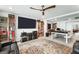 Spacious living room with a large TV, ceiling fan, and extensive shelving at 8415 Iron Heart Ln, Las Vegas, NV 89113