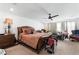 A large main bedroom featuring comfortable carpets, a ceiling fan, and a private bath entrance at 8415 Iron Heart Ln, Las Vegas, NV 89113
