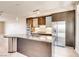 Modern kitchen features stainless steel appliances, dark cabinetry and an island with granite countertop at 8925 W Flamingo Rd # 310, Las Vegas, NV 89147