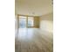 A spacious, empty living room with laminate flooring and sliding glass doors to the balcony at 8925 W Flamingo Rd # 310, Las Vegas, NV 89147