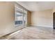 Empty room showcasing light-colored laminate flooring and a large window showing an exterior balcony at 8925 W Flamingo Rd # 310, Las Vegas, NV 89147