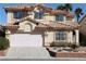 Inviting two-story home with a terra cotta tile roof, a well-manicured lawn and a two car garage at 8982 Emerald Waters Ct, Las Vegas, NV 89147