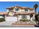 Inviting two-story home with a terra cotta tile roof, a well-manicured lawn and a two car garage at 8982 Emerald Waters Ct, Las Vegas, NV 89147