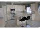 Well-lit kitchen with white cabinets, an island with stools, and a window overlooking the backyard at 8982 Emerald Waters Ct, Las Vegas, NV 89147