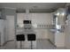 Traditional kitchen with white cabinetry, tile backsplash, and island with breakfast bar seating at 8982 Emerald Waters Ct, Las Vegas, NV 89147
