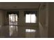 Bright living room with tile flooring, large windows, and a sliding glass door leading to the outdoor patio at 8982 Emerald Waters Ct, Las Vegas, NV 89147