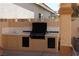 This outdoor kitchen features a built-in grill, sink, and ample counter space perfect for entertaining at 8982 Emerald Waters Ct, Las Vegas, NV 89147