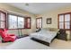 Cozy bedroom with carpet, bay window, shuttered windows, and a comfortable red chair at 9092 National Park Dr, Las Vegas, NV 89178