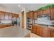 Close-up view of the kitchen features double ovens, tile backsplash, and wood cabinetry at 9092 National Park Dr, Las Vegas, NV 89178