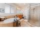Luxurious bathroom featuring soaking tub, glass enclosed shower, and vanity with tile flooring at 9165 Tudor Park Pl, Las Vegas, NV 89145