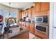 Bright kitchen with granite countertops, stainless appliances, wooden cabinetry, and a breakfast nook with a view at 9165 Tudor Park Pl, Las Vegas, NV 89145