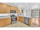 Modern kitchen featuring stainless steel appliances, light wood cabinets, and marble countertops at 9788 Altadena St, Las Vegas, NV 89183