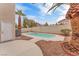 A private backyard pool is surrounded by desert landscaping, palm trees, and a stucco wall for enhanced seclusion at 9788 Altadena St, Las Vegas, NV 89183