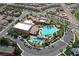 An aerial view of a community center featuring multiple pools, palm trees, tennis court and ample parking at 1026 Via Saint Andrea Pl, Henderson, NV 89011