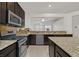 Well-equipped kitchen with granite countertops, stainless steel appliances, and dark wood cabinetry at 1026 Via Saint Andrea Pl, Henderson, NV 89011