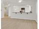 Open-concept living area with wood-look floors and a bar area with a view into the kitchen at 1026 Via Saint Andrea Pl, Henderson, NV 89011